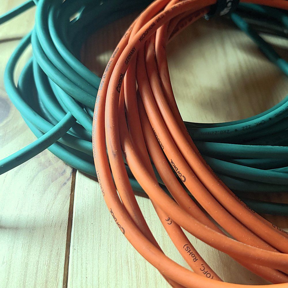 Câbles XLR enroulés sur le parquet
